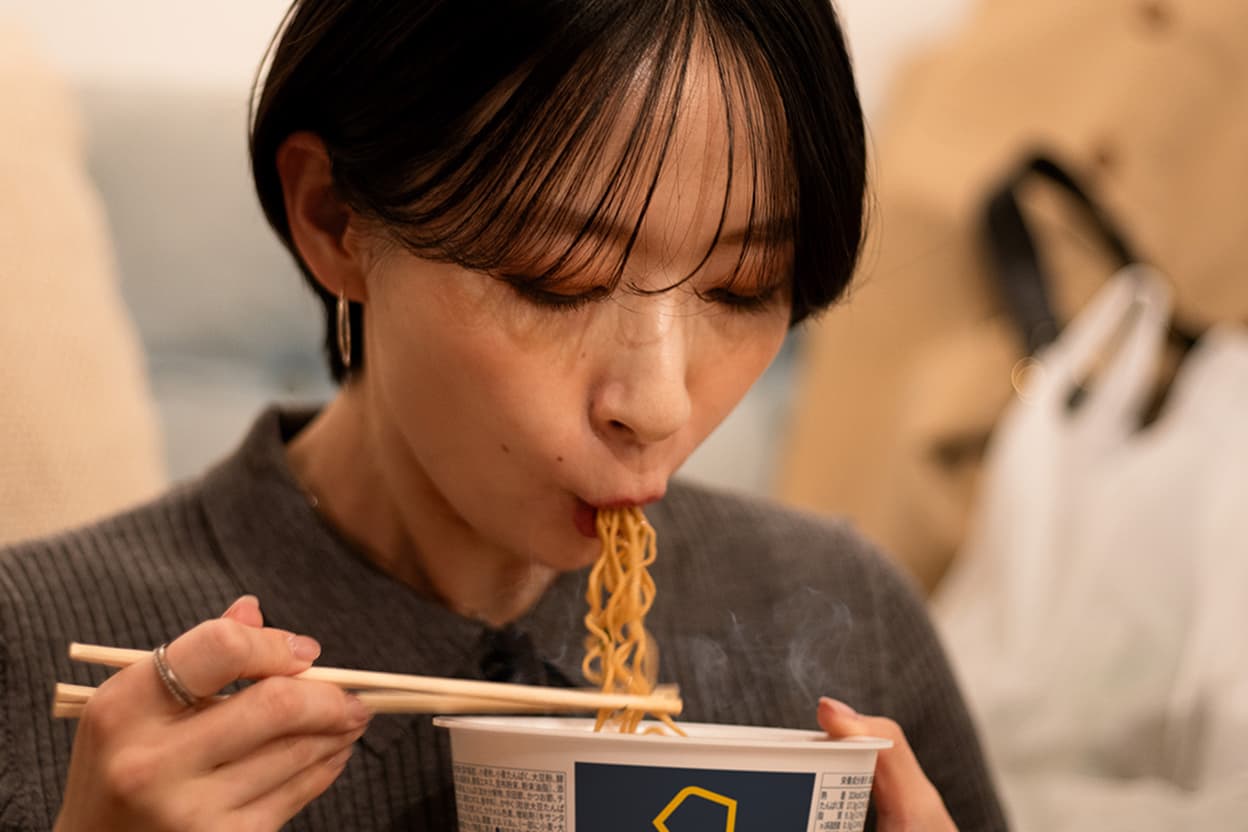 BASE YAKISOBA を食べる女性