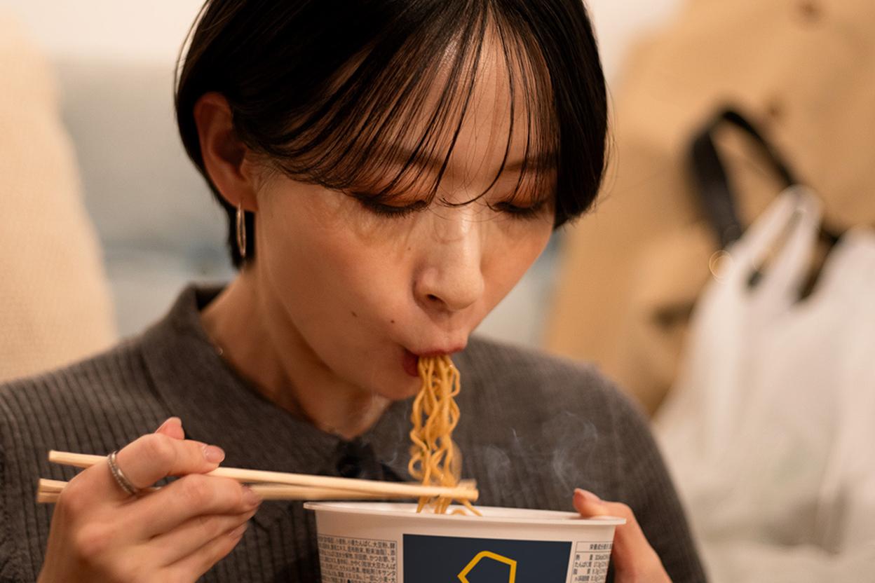 BASE YAKISOBA を食べる女性