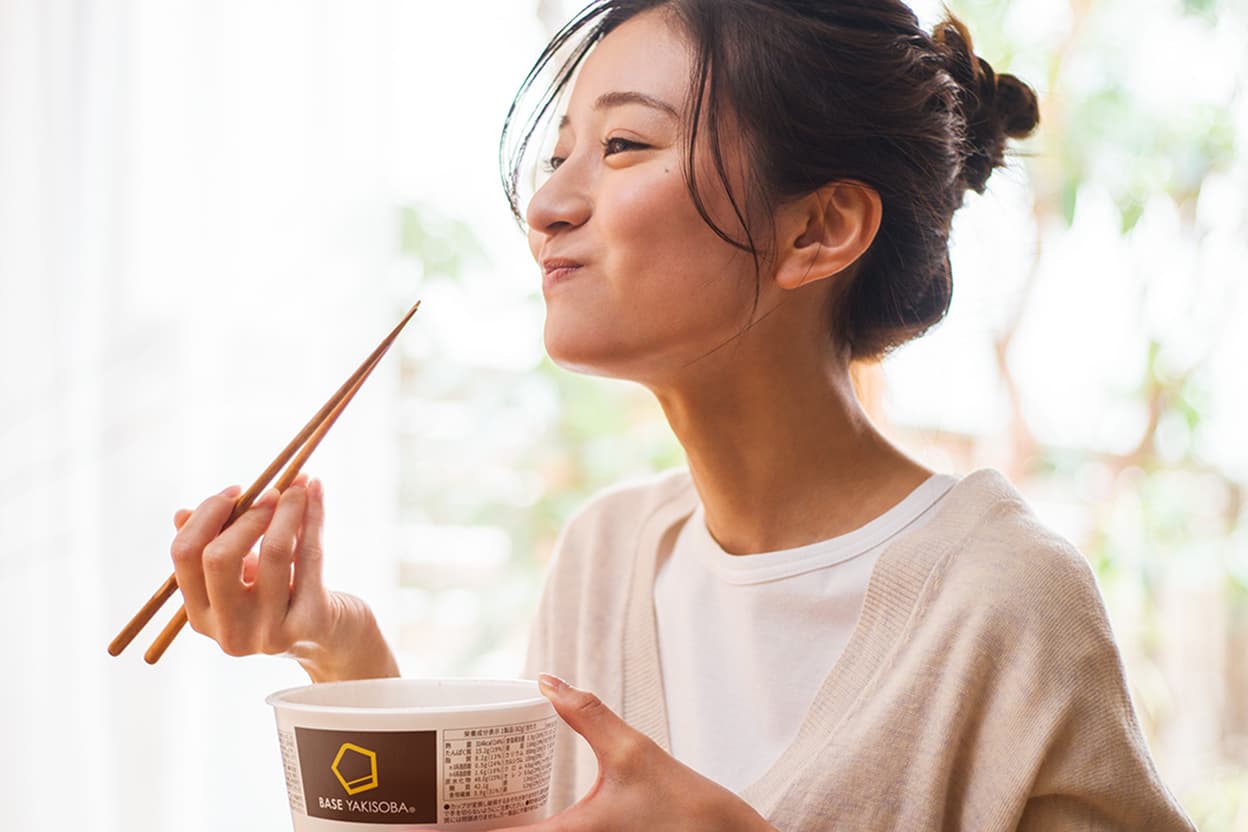 BASE YAKISOBA を食べる女性
