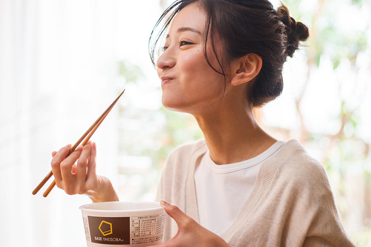 BASE YAKISOBA を食べる女性
